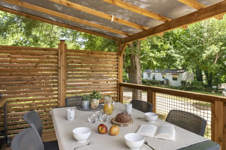 Table de terrasse avec petit-déjeuner et livres.